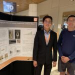 Mike and Lu are standing in front of the research poster.