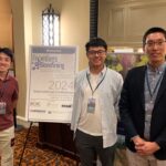 Xuan Li, Kehao Ren, Lu Wang stand in front of the conference logo.